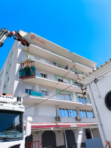 Grúa subiendo barandillas de cristal para instalación
